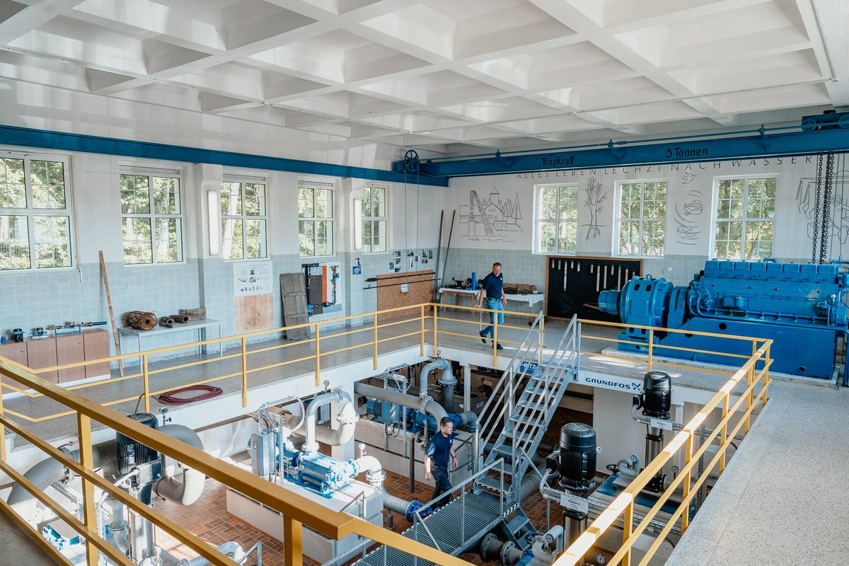Pumpenhalle mit hoher Decke und blau-gelben Geländern
